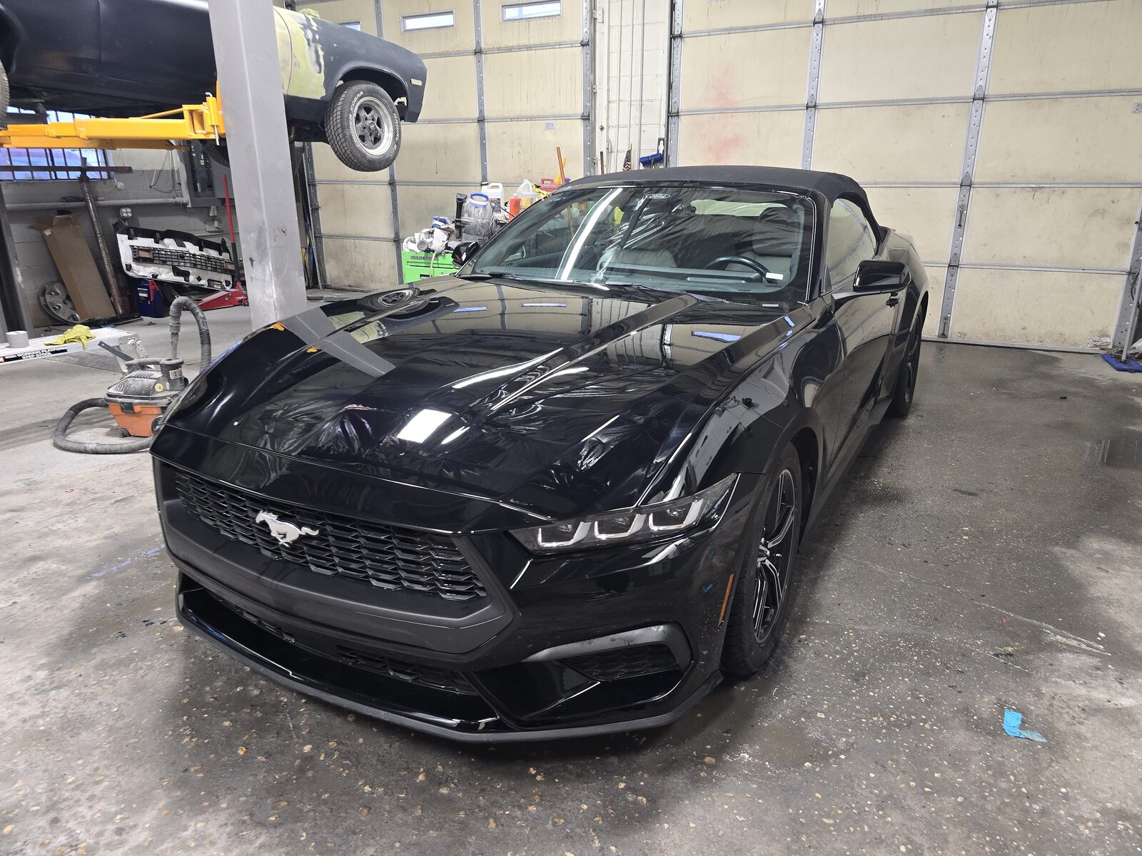 Black convertible parked in the shop after refinishing