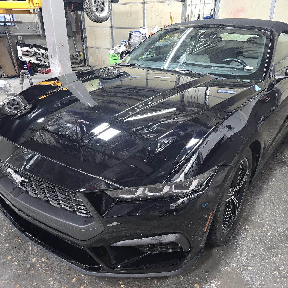 Refinished black convertible in the shop, ready for pickup